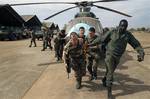 Malian soldiers helped by French troops, move a broken helicopter out a hangar to make room for more incoming troops at Bamako's airport Tuesday Jan. 15. 2013. French forces led an all-night aerial bombing campaign Tuesday to wrest control of a small Malian town from armed Islamist extremists who seized the area, including its strategic military camp. A a convoy of 40 to 50 trucks carrying French troops crossed into Mali from Ivory Coast as France prepares for a possible land assault. Several th