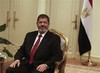 RETRANSMISSION FOR ALTERNATE CROP - Egyptian President Mohammed Morsi looks on during a photo opportunity during his meeting with Turkish Ambassador to Egypt, Hussein Awny and Turkish Foreign Minister Ahmet Davutoglu, unseen, at the Presidential Palace in Cairo, Egypt