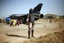 A Malian special forces soldier stands guard in front of a French Mirage fighter jet on the military side of Bamako's airport Wednesday Jan. 16, 2013, during a joined visit to French and Malian troops by Mali's President Dioncounda Traore and French Ambassador to Mali Christian Rouyer. French troops pressed northward in Mali toward territory occupied by radical Islamists on Wednesday, military officials said, announcing the start of a land assault that will put soldiers in direct combat "within hours."