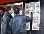 Algerian men look at national newspapers headlining the terrorist attack and kidnapping in Amenas at a news stand in Algiers, Thursday, Jan. 17, 2013.