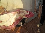 In this undated photo, a man stands next to the body of an unidentified person near Ain Amenas, Algeria. Algerian bomb squads scouring a gas plant where Islamist militants took dozens of foreign workers hostage found "numerous" new bodies on Sunday, Jan. 20, 2013 as they searched for explosive traps left behind by the attackers, a security official said, a day after a bloody raid ended the four-day siege of the remote desert refinery.