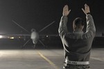 File - A staff sergeant marshalls an MQ-9 Reaper after it returned from a mission Dec. 1, 2010, at Kandahar Airfield, Afghanistan.