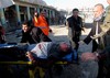 People evacuate an injured man after a bomb attack that struck the local headquarters of the Kurdistan Democratic Party in Kirkuk, 180 miles (290 kilometers) north of Baghdad, Iraq, Wednesday, Jan. 16, 2013.