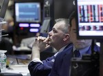 In this Feb. 25, 2010 file photo, Trader Albert Young, left, studies his screens as he works on the floor of the New York Stock Exchange