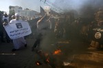 File - Palestinian Salafis "al-Qaeda" burning U.S. and Israeli flags as they burn an image of U.S. President Barack Obama during a protest against what they said was a film being produced in the U.S. that was insulting to the Prophet Mohammad in Rafah in southern Gaza Strip on September 14, 2012.