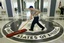 A workman quickly slides a dustmop over the floor at the Central Intelligence Agency headquarters where President Bush and CIA Director Porter Goss would be standing for a news briefing during Bush's visit to the super-secret facility in Langley, Va., near Washington, Thursday, March 3, 2005.