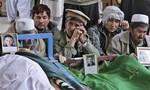 Pakistani relatives of Saturday's bombing victims mourn next to their bodies in a mosque in Quetta, Pakistan, Sunday, Feb. 17, 2013.