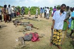 Villagers view the bodies of suspected attackers from the Pokomo tribe, following tribal clashes in Kipao village in the Tana River Delta region of southeastern Kenya Friday, Dec. 21, 2012.