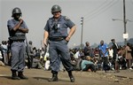 File photo: South African police officers stand next to a group of protesters