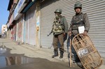 Indian paramilitary troops stand guard in front of closed market in Srinagar on Friday 01, March 2013. As Kashmir valley observed a strike called by separatists in support of their demand for return of mortal remains of Afzal Guru Parliament attack convict, in Srinagar on Friday 01, March 2013.