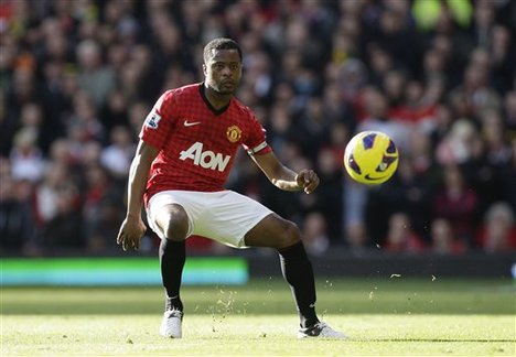 Manchester United's Patrice Evra takes the ball downfield during his team's English Premier League soccer match against Arsenal at Old Trafford Stadium, Manchester, England, Saturday, Nov. 3, 2012.