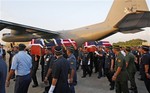 Malaysian police officers carry the coffins of two policemen who were killed in an ambush in Semporna, Malaysia, as they arrive at the Royal Malaysian Air Force base in Subang, near Kuala Lumpur, Malaysia, Monday, March 4, 2013. Malaysia sent hundreds of soldiers to a Borneo state on Monday to help neutralize armed Filipino intruders who have killed eight police officers in the country's bloodiest security emergency in years. (AP Photo/Lai Seng Sin)