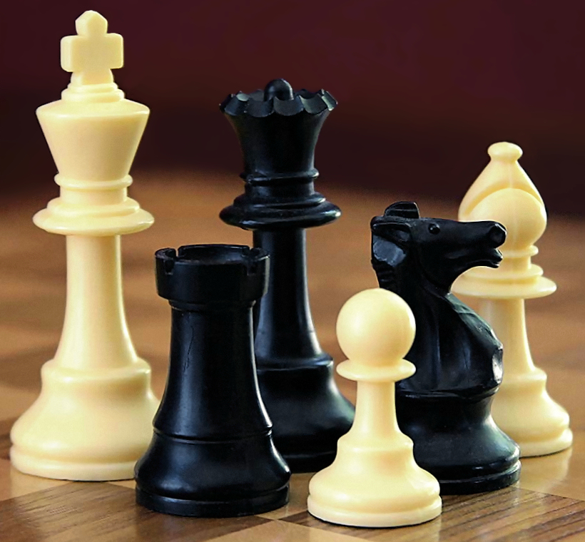 A selection of black and white chess pieces on a chequered surface.