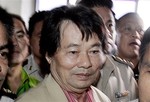 Somchai Khunpleum, center, is surrounded by Thai prison officials as he is taken out of the appeal court room in Bangkok, Thailand Wednesday, Oct. 12, 2005. Thai appeal court on Wednesday reconfirm the preliminary court sentenced to 25 years jail term for Somchai, who is the father of two members of parliament of ruling Thai Rak Thai party, on charges of conspiring to hire the gunman to kill his business rival.