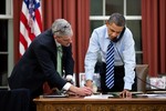 File - President Barack Obama confers with Chief of Staff Denis McDonough as he talks on the phone in the Oval Office, Feb. 6, 2013.