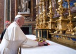 In this photo provided by the Vatican newspaper L'Osservatore Romano, Pope Francis puts flowers on the altar inside St. Mary Major Basilica, in Rome, Thursday, March 14, 2013.