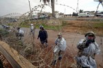 File - Egyptian soldiers use barbed wire to close a part of a destroyed section of the border wall between the Gaza Strip and Egypt January 29, 2008.