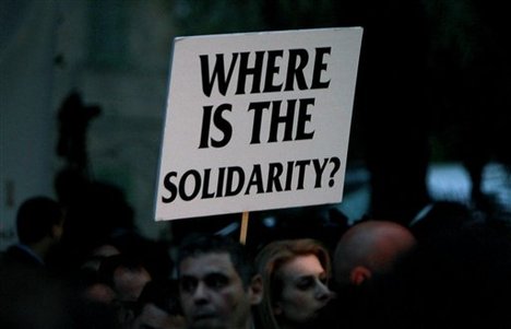 Employees of Laiki Bank hold a banner during an anti-bailout protest outside the Cypriot parliament in Nicosia, Cyprus, Thursday, March 21, 2013.