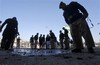 Pakistani police officers examine the site of a suicide bombing in Peshawar, Pakistan on Monday, Jan. 31, 2011. A suicide car bomber attacked a vehicle carrying a senior Pakistani police official in the northwestern city of Peshawar on Monday, killing him and two others, said police.