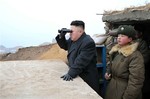 In this March 7, 2013 photo released by the Korean Central News Agency (KCNA) and distributed March 8, 2013 by the Korea News Service, North Korean leader Kim Jong Un, center, uses binoculars to look at the South's territory from an observation post at the military unit on Jangjae islet, located in the southernmost part of the southwestern sector of North Korea's border with South Korea.