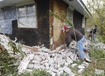 File - Chad Devereaux examines bricks that fell from three sides of his in-laws home in Sparks, Okla. on Sunday, Nov. 6, 2011 after two earthquakes hit the area in less than 24 hours. A team of scientists have determined that a 5.6 magnitude quake in Oklahoma in 2011 was caused when oil drilling waste was injected deep underground.