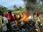 In this Feb. 6, 2013 file photo, bystanders watch as a woman accused of witchcraft is burned alive in the Western Highlands provincial capital of Mount Hagen in Papua New Guinea.