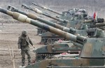 A South Korean Marine stands on a K-55 self-propelled howitzer during a military exercise against possible attacks by North Korea near the border village of Panmunjom in Paju, South Korea, Wednesday, April 3, 2013.