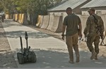 File - A TALON robot attracts attention on a test drive down Disney drive after repairs at the Joint Robotic Repair Detachment shop Oct. 27, 2011, at Bagram Airfield, Afghanistan.