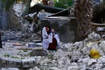 An Iranian woman reacts as she sits among the rubble of buildings after an earthquake struck southern Iran, in Shonbeh, Iran, Tuesday, April 9, 2013.