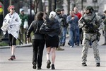 As Boston Marathon runners walk by, SWAT team members stand guard near the finish line in Boston Monday, April 15, 2013.