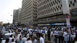 People evacuate buildings and gather on road after a tremor of an earthquake was felt in Karachi, Pakistan, Tuesday, April 16, 2013.