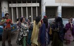 People evacuate buildings and gather on road after a tremor of an earthquake was felt in Karachi, Pakistan, Tuesday, April 16, 2013.