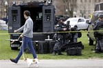 A man walks a dog as officials suit up in tactical gear at Boston Common, Tuesday, April 16, 2013, one day after bombs exploded at the finish line of the Boston Marathon.