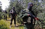 In this Friday, April 12, 2013 photo, members of the Lebanese pro-Syrian Popular Committees stand guard at the Lebanon-Syria border, near the northeastern Lebanese town of al-Qasr, Lebanon.