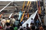 Rescue workers use clothes to bring down survivors and bodies after an eight-story building housing several garment factories collapsed in Savar, near Dhaka, Bangladesh, Wednesday, April 24, 2013.