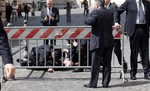 A wounded Carabinieri paramilitary police officer is assisted after being shot at outside the Chigi Premier's office, in Rome, Sunday, April 28, 2013.