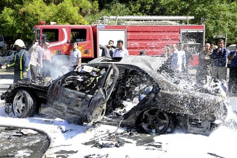 This photo released by the Syrian official news agency SANA, shows Syrian fire fighters extinguishing burning cars after a car bomb exploded in the capital's western neighborhood of Mazzeh, in Damascus, Syria, Monday, April. 29, 2013.