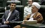 In this Sunday, May 27, 2012, file photo, former Iranian President Akbar Hashemi Rafsanjani, right, listens to President Mahmoud Ahmadinejad, left, in an inauguration ceremony of the parliament in Tehran, Iran.