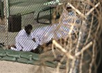 In this May 14, 2009 file photo, reviewed by the U.S. military, Guantanamo detainees pray before dawn near a fence of razor-wire, inside Camp 4 detention facility at Guantanamo Bay U.S. Naval Base, Cuba