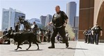 A Department of Homeland Security police officer patrols with his dog outside the Moakley Federal Courthouse in Boston, Mass., Wednesday, May 1, 2013.