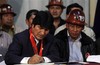 Bolivia's President Evo Morales, left, signs the new retirement law in La Paz, Bolivia, Friday, Dec. 10, 2010.