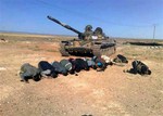 This citizen journalism image provided by The Syrian Revolution Against Bashar Assad which has been authenticated based on its contents and other AP reporting, shows Syrian rebels praying in front their tank, at al Mutayia village, in the southern province of Daraa, Syria, Tuesday April 30, 2013.