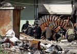 File - This citizen journalism image provided by Aleppo Media Center AMC which has been authenticated based on its contents and other AP reporting, shows members of the free Syrian Army hiding behind scrap metal during an attack against Syrian government forces, in the neighborhood of al-Amerieh in Aleppo, Syria, Sunday, April. 21, 2013.