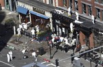 In this Wednesday, April 17, 2013 file photo, investigators comb through the scene of one of the blast sites of the Boston Marathon explosions in Boston.