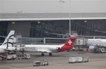 Baggage carts make their way past a Helvetic Airways aircraft from which millions' of dollars worth of diamonds were stolen on the tarmac of Brussels international airport, in this Feb. 19, 2013 file photo.