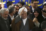 Former President Akbar Hashemi Rafsanjani waves to reporters, as he registers his candidacy for the upcoming presidential election, at the election headquarters of the interior ministry in Tehran, Iran, Saturday, May 11, 2013.