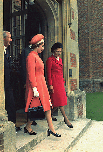 Elizabeth and Pat Nixon walk out of a red-brick building in step