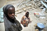 File - Two girls help to prepare food for builders working on Haji Mohamud Hilowle Primary School in Wadajir district, Mogadishu, Somalia.