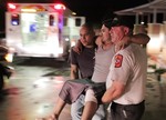 Johnny Ortiz, left, and James South, right, carry Miguel Morales, center, who was injured in a tornado, to an ambulance in Granbury, Texas, on Wednesday May 15, 2013.