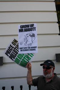 Protestor with placards - 'Grow Up Mr Abbott'